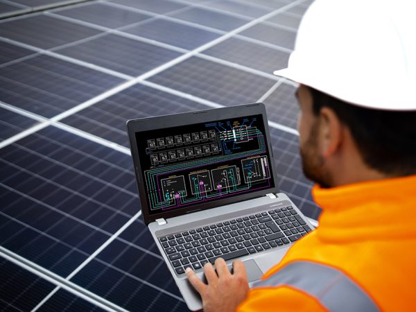 Solar panels installation for sustainable energy. Electrical engineer holding laptop computer with solar panels scheme and checking productivity.